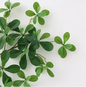 Close-up detail shot of artificial green banyan leaves, perfect for indoor home decor.