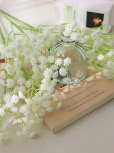 Artificial baby breath flower bouquet in glass vase home decor aesthetic detail shot