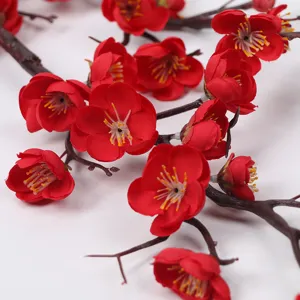 Realistic red artificial plum blossoms with detailed petals on elegant brown branches