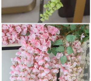 Close-up detail of realistic pink artificial wisteria flowers with vibrant green leaves