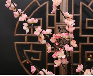 Detailed close-up of artificial plum blossom branches, pink faux flowers for interior decoration.