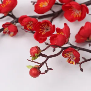 Artificial plum blossom branch for home decoration, vivid red floral arrangement.