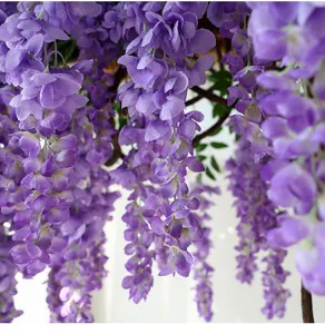 Detailed close-up of realistic purple artificial wisteria flower silk petals hanging down.