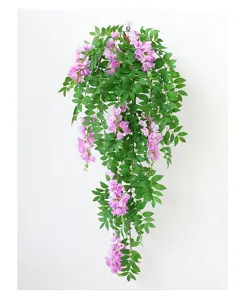 Primo piano di glicine appeso artificiale con fiori rosa e foglie verdi decorative