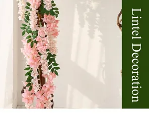 Detailed view of pink artificial wisteria vine hanging against a white wall with shadows