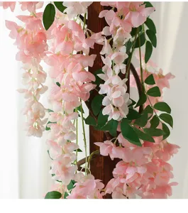 Close-up of pink artificial silk wisteria flowers hanging on a wooden pillar