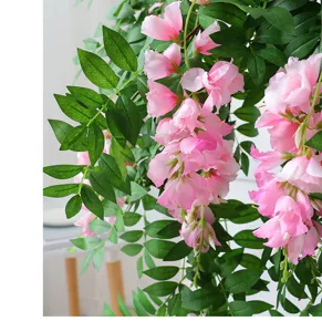 Vista dettagliata di una vite di fiori artificiali pendenti rosa con foglie verdi