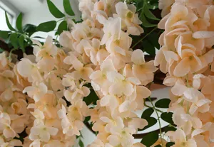 Close-up detail of champagne artificial wisteria flowers for indoor decoration.