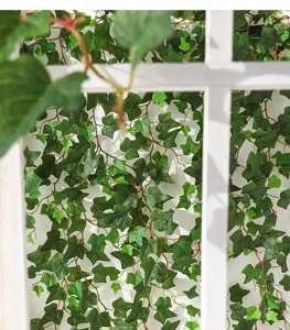 Detailed view of realistic artificial ivy garland on white lattice for wall decor