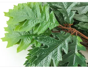 Artificial camphor tree branch green plant detail shot, realistic foliage for home decor.