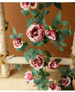 Vista detallada de enredaderas de peonías artificiales con pétalos rosas y hojas verdes.