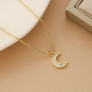 Detailed view of a gold-plated crescent moon pendant necklace featuring sparkling zircon crystals