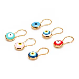 Dettaglio di spille da balia Evil Eye turche colorate con una lucida finitura dorata