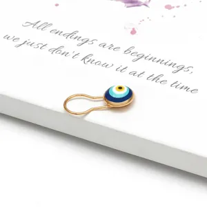 Dettaglio ravvicinato della spilla turca Evil Eye in smalto blu su sfondo bianco