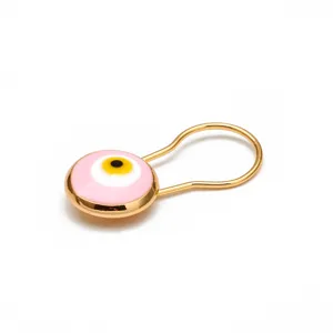 Dettaglio macro di spilla retrò con occhio greco rosa e finitura in oro lucido