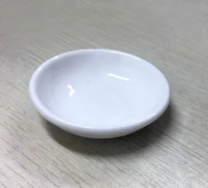 Primer plano detallado de un pequeño plato de cerámica blanca de 4 pulgadas en madera