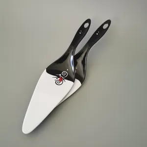 Detailansicht von zwei eleganten schwarz-weißen Tortenhebern aus Melamin mit Blumen.