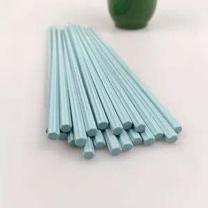 Primo piano di bacchette in melamina esagonale azzurro chiaro, dettaglio stoviglie.