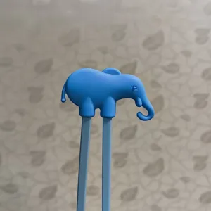 Kids training chopsticks with cute blue elephant silicone topper detail view for toddlers learning.