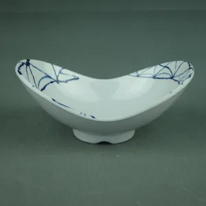 Close-up detail of an irregular white melamine Yuanbao bowl with elegant blue patterns