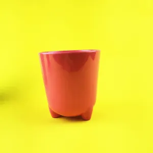 Pink ceramic three-leg cup detail view, smooth surface finish, minimalist design shot.