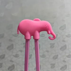 Pink elephant silicone head detail on children training chopsticks, cute baby learning tableware.