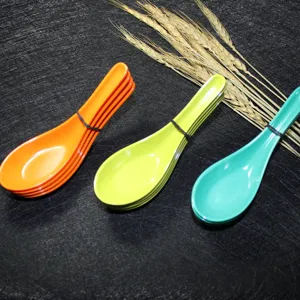 Detail view of vibrant melamine Chinese soup spoons in orange, lime green, and teal colors