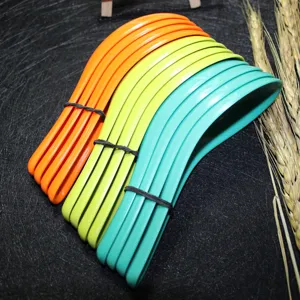 Colorful melamine soup spoons set in orange, green, and teal, stacked for detail.
