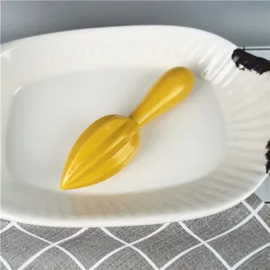 Yellow plastic manual lemon squeezer kitchen muddler tool for bar and beverage preparation.