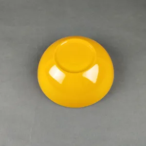 Detailed bottom view of yellow melamine salad bowl showcasing smooth glossy finish.