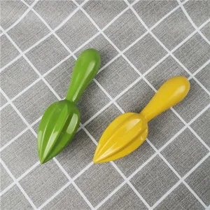 Detail view of manual lemon juicer sticks, dual green and yellow colors, kitchen tool.