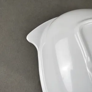Weiße Melamin geteilte Platte Detailaufnahme, glatte Oberfläche, kreatives Eckdesign.