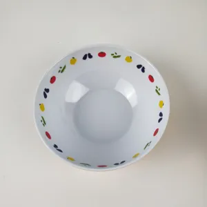Detail view of white melamine salad bowl with vibrant fruit rim patterns for kids.