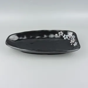 Black melamine plate detail view featuring elegant cherry blossom pattern design for restaurant.