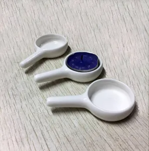 Detalle de portavelas de cerámica blanca con vela de té morada