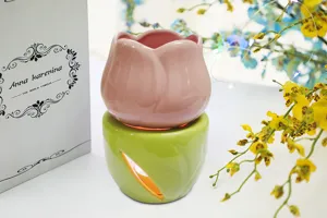 Detailweergave van de keramische tulp aromabrander, gesplitst ontwerp met roze top en groene basis.