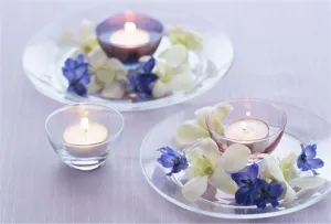 Élégants bougeoirs en verre avec bougies chauffe-plat et décoration florale pour table de mariage.