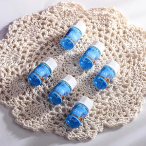 Sei bottigliette di oli per aromaterapia all'oceano su un centrino decorativo bianco