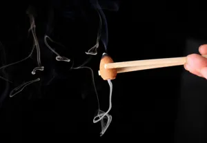Primo piano di un cono di incenso a riflusso acceso con fumo bianco