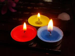 Sfeervolle brandende gekleurde waxinelichtjes in aluminium cups voor romantiek