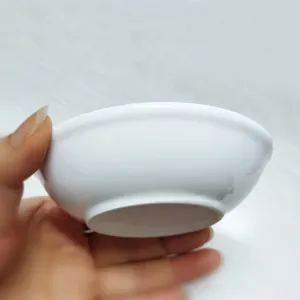 Vista de mano de un platillo minimalista de cerámica blanca de 4 pulgadas con base lisa