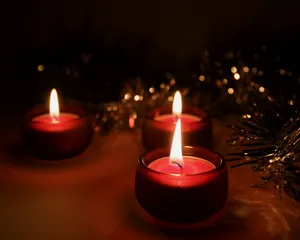 Warme close-up van drie rode brandende theelichtjes voor een feestelijke sfeer.