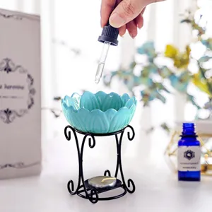 Ceramic lotus aroma diffuser with black metal stand and tealight candle for essential oil.