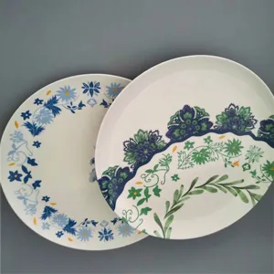 Lot de deux assiettes rondes en mélamine avec d'élégants motifs floraux bleus et verts.
