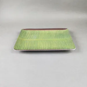 Détail d'assiette en mélamine feuille de bananier, vaisselle durable au motif de feuillage.