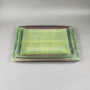 Vue détaillée d'assiettes rectangulaires en mélamine avec un motif de feuille de bananier.