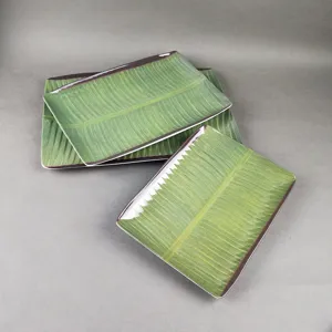 Assiette rectangulaire en melamine avec un design realiste de feuille de bananier vert.