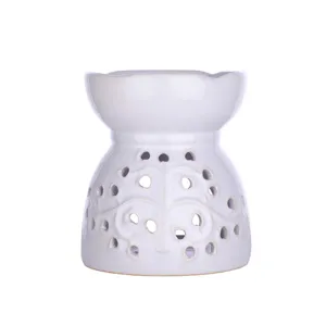 White ceramic essential oil burner and wax melt warmer for cozy home fragrance decor.