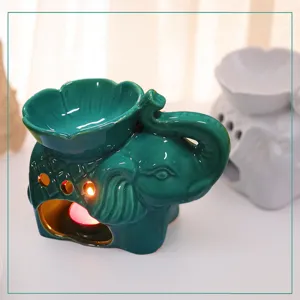 Elegante quemador de aceite de cerámica de elefante verde con portavelas en forma de pétalo.