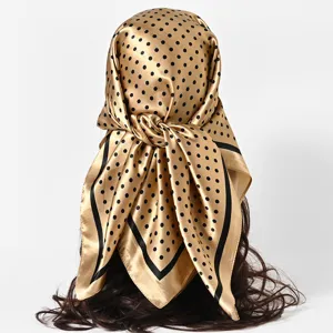 Detailed view showing the texture of a gold polka dot satin scarf tied as a headscarf.